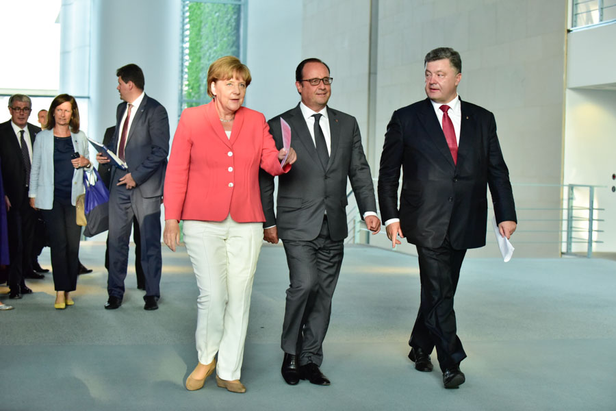 Merkel, Hollande and Poroshenko stroll towards the press conference.