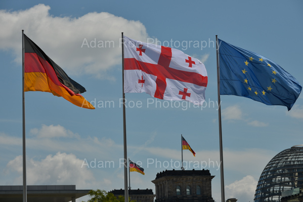 The flags of Germany, Georgia and the European Union fly at the Federal Chancellory. The German Bundestag and its flags are in the background.