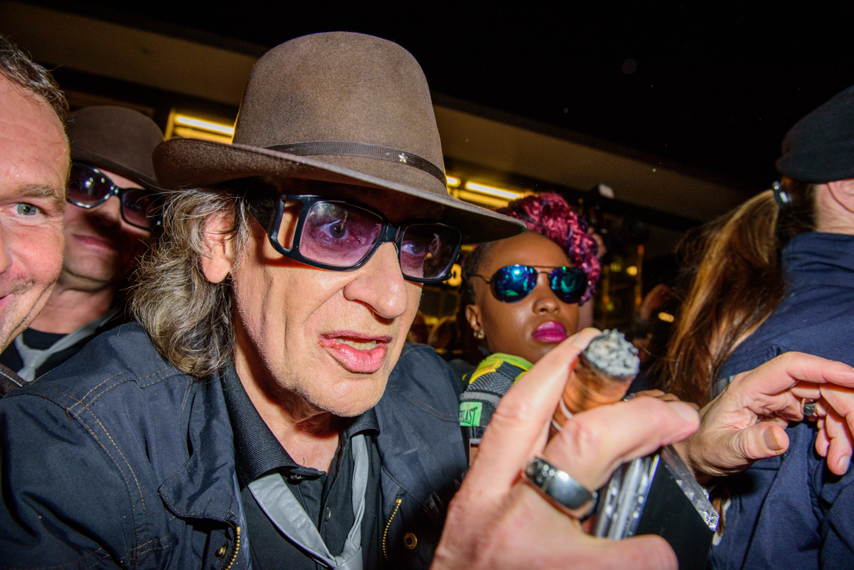 Of goes Udo Lindenberg with hat, sunglasses and cigar.