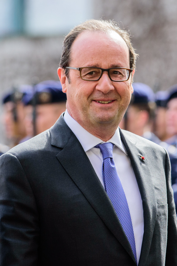 Francois Hollande stroll through the courtyard at the German Federal Chancellery.