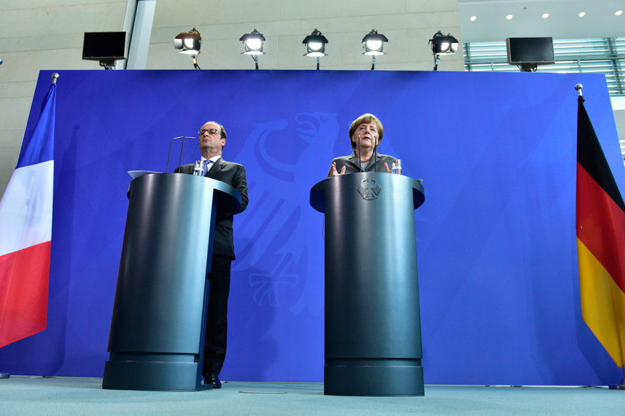 Flags, Podiums, Politicians: Francois Hollande and Angela Merkel address the press together.