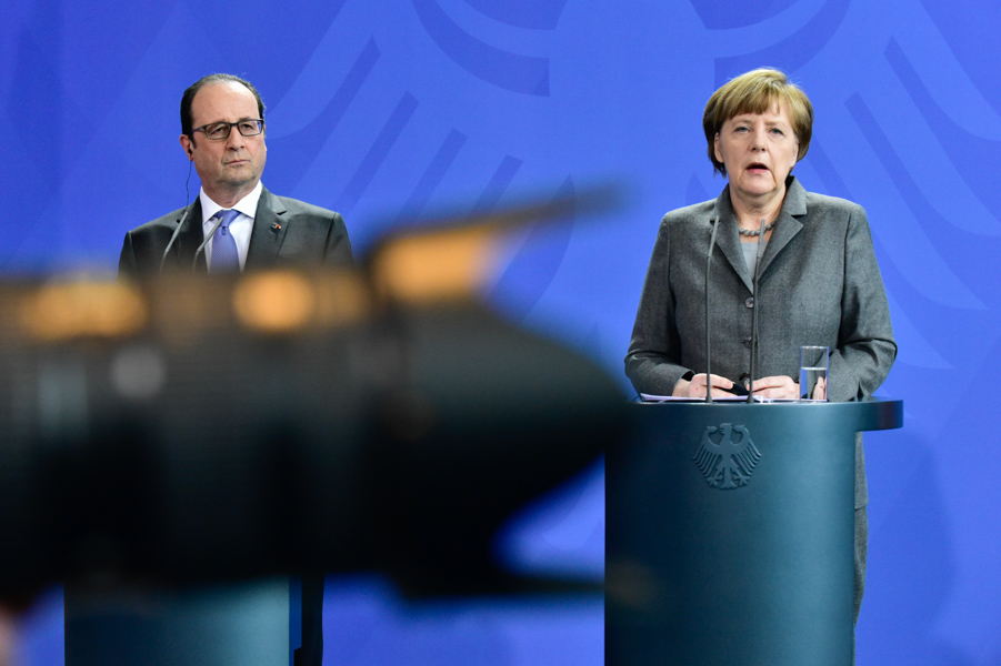 When press conferences go on too long, we get restless. The AFP photographer next to me was aiming for reflections in the glass, I went for his lens crossing Hollande towards Merkel. 
