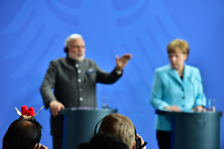 Modi, Merkel, and that photographer with a bird on his flash, or something. 