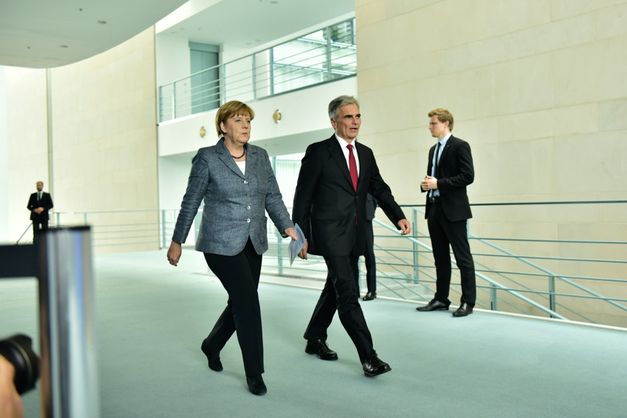 Merkel and Austrian Prime Minister Werner Faymann stroll to their press conference.