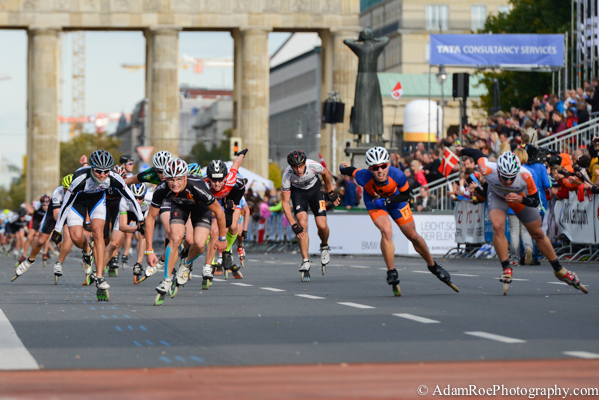Inline Skaters sprint to the finish line of the Berlin Marathon with the Brandenburg Gate behind them