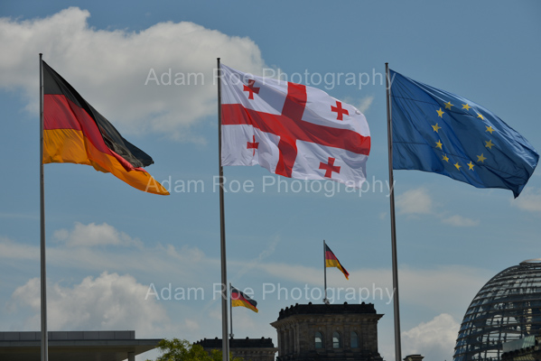 The flags of Germany, Georgia and the European Union fly at the Federal Chancellory. The German Bundestag and its flags are in the background. 